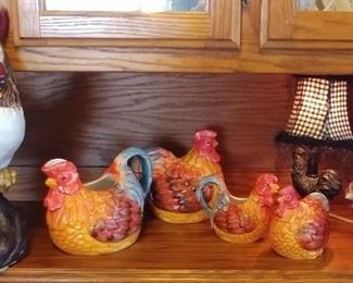Chicken & Rooster Lot Including: Large Rooster Ceramic, Small Chicken Ceramic, (Coffee, Cookie, Creamer & Sugar Set), Small Chicken Lamp, Red Metal Trivet, and Chicken Plate Stand. Asking $59.00 for the lot