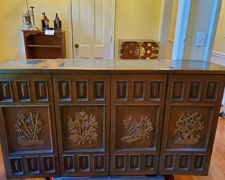 Beautiful teak carved wood vintage bar front view. Three section marble top