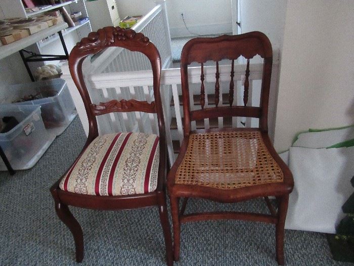 set of spindle back chairs with caned seats.  Carved crest on other chair. 