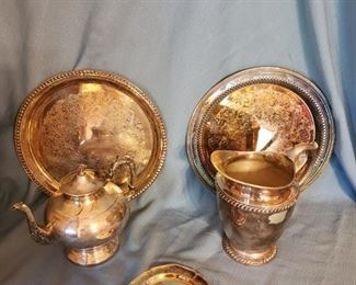 P-LR-138    $60     Silver on copper Teapot, WM Rogers Siver Plate pitcher, WM Rogers Silver plate small plate, WM  Rogers Silver plate platter, Oneida Silver plate platter