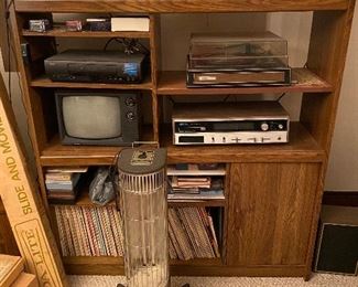 Media stand, TV, VHS, Stereo, Turntable, records (German, orchestra, beer drinking); space heater, DA-LITE projector screen, more