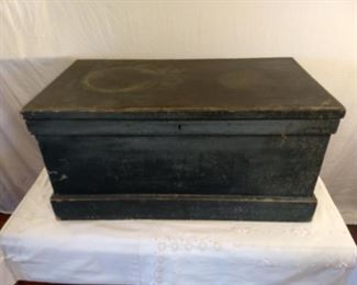 Large dark green wooden storage box or blanket chest with a stamp from D. L. KIMBALL on inside lid. Box has some paint damage on the outside.