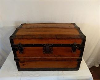 Antique captain's chest with ornate hand fitted metal construction with rivets. Bowed top with clasps and lock with working hinged lid.