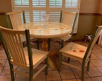 Matching hand painted table with four chairs and glass top