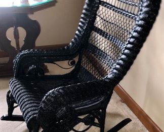 Antique black wicker rocker