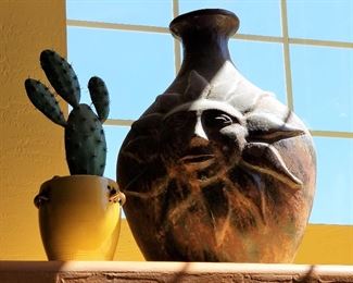 Decorative faux cactus and southwest sun style pottery.