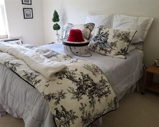 This is a queen bed in the guest room. The toile duvet cover and shams are a cream and white color and the rest of the sheets are a lovely pale blue.