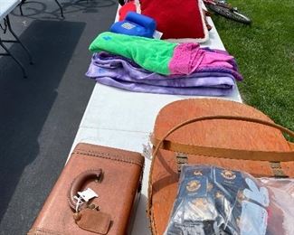 Vintage suitcase, picnic basket, blankets and throw pillows