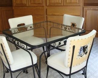 60's Wrought iron table with glass top and four chairs. Heavy weight