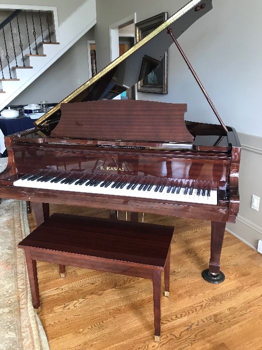 Elegant K Kawai Bay Grand Piano with bench. Mahogany finish with strong grain. Beautiful Response and touch. Cared for by McQuary.