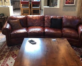 Handsome leather sectional, bar chairs, mesquite coffee table in a handsome home.