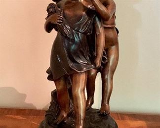 Item 32: A reproduction bronze sculpture after French Rococo sculptor Claude Michel Clodion (1738-1814) titled Secret. It depicts a young girl in a dress dress and a grouping of flowers in her arm; She has a boy whispering who knows what in her ear - 17.5": $250