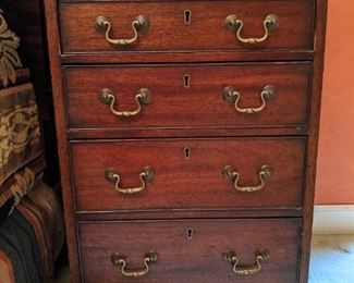 One of a pair of antique English wooden 4-drawer chests, with pull-out top shelf.