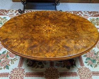 Top of an antique inlaid burl wood coffee table.