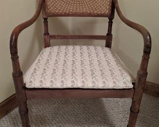 One of a pair of faux bamboo armchairs, with spider web wicker back and seat.