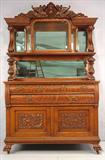 300 - Heavily Carved Oak Sideboard w winged griffin crown and china cabinet top in original finish, att. To R.J. Horner, 89 in. T, 54 in. W, 25 in. D, ca. 1900.