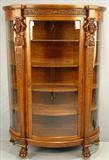 134 - Oak Curved Glass China Cabinet by R.J. Horner with atlas carved columns and claw feet, 70 in. T, 46 in. W, 16 in. D, ca. 1900