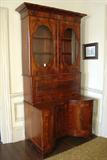 400 - Mahogany Empire Drop Front Secretary with concave base figured veneer and birdseye interior, oval glass doors at top, 91 in. T, 23 in. W, 26 in. D, ca. 1850.