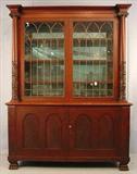 359 - Mahogany Empire Breakfront with acanthus carved column front, mirrored back and leaded glass doors, claw feet, ca. 1880, 78in. T, 59in. W, 23in. D.