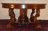 107 - Mahogany Dolphin Carved Dining Table, 60in. Round, opens to 12ft with 6 leaves by R.J. Horner.