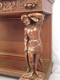 111 - 1911 Server by Oriel Cabinet Co. that features massively carved mascarons, Norman soldiers, atlantes and caryatid figures as well as griffins in full relief (part of the "Norman Suite"), 66in. tall, 54in. wide, 24in. deep (atlantes figure)