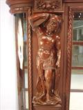 110 - 1911 China Cabinet by Oriel Cabinet Co. that features massively carved mascarons, Norman soldiers, atlantes and caryatid figures as well as griffins in full relief (part of the "Norman Suite"), 94in. tall, 66.5in. wide, 19in. deep (atlantes figure)