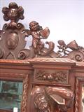 110 - 1911 China Cabinet by Oriel Cabinet Co. that features massively carved mascarons, Norman soldiers, atlantes and caryatid figures as well as griffins in full relief (part of the "Norman Suite"), 94in. tall, 66.5in. wide, 19in. deep (atlantes figure, 3)