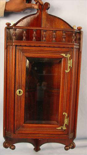 156 - Hanging Walnut Corner Cabinet with beveled glass door and  spindle gallery top, 29in. T, 13in. W., ca. 1890