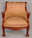 393 - Solid Mahogany arm chair with carved lions head on  arms and claw feet, has lavender upholstery, 36in. T, 28in. W, 23in. D.