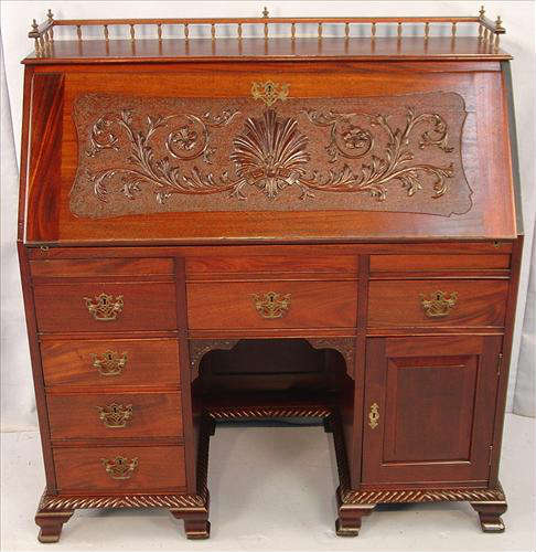 453 - Mahogany Slant Front Desk with carved front and brass gallery, 43in. W, 45in. T, 19in. D., ca. 1890.