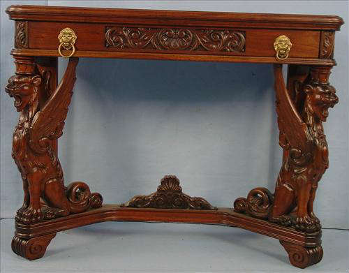 491 - Mahogany Console Table with carved full body winged griffins and brass lions head pulls, 31in. T, 40in. W, 17in. D. with white marble top.