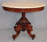 107 - Walnut Victorian oval marble top parlor table by T. Brooks, heavily carved base, 34in. L, 26in. W.