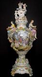 156 - Tall Dresden Capped Urn, applied flowers, figurals, 34in. T, 16in. W, has cupids on lid, roses painted on back side.