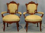 318 - Pair of walnut Victorian armed parlor chairs with green and gold upholstery, carved crowns, ca. 1875.