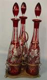 1105 - Bohemian cranberry cut to clear wine set with original stopper, silverplate rack, ca. 1890.