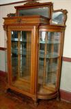 2 - Large oak curved glass china cabinet with lion heads in crown, top mirror panel, glass shelves and  claw feet.
