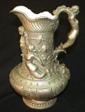 232 - Silver Over Copper Over Porcelain Pitcher with Figural Decoration and Repaired Spout 10.5 in. T. X 6.5 in.