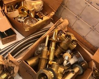 Lots of brass and gold plated bathroom plumbing handles and piping