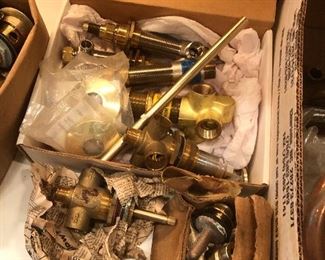Lots of brass and gold plated bathroom plumbing handles and piping