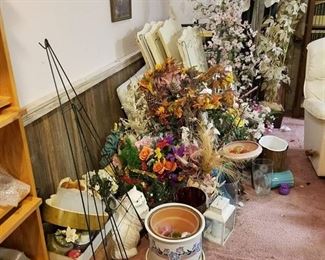 contents along basement wall - artificial flowers, 2 wreath stands, old treadmill, mirror, belts and belt rack , Etc