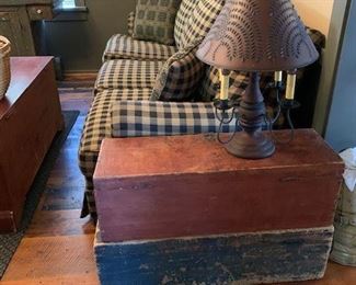 Two original surface and painted storage boxes, one in old red and the other in blue.  Contemporary lamp with punched tin shade.  Johnston Benchworks sofa. 