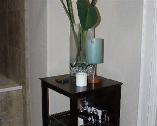 Cappuccino Stand with 2 Pull-Out Gallery Shelves (30”H x 16” W x 15”D). Large Bird of Paradise Floral Arrangement in a 15” Square Glass Vase