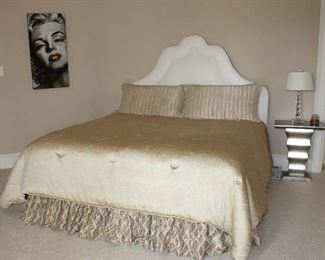 White Faux Leather Padded King Size headboard and a Custom Made Silk Reversible Champagne/Brown Comforter and Dust Ruffle with a pair Thomas IO’Brien shams and Pillow. Also shown: a pedestal Champagne Pedestal Side Table and a Herminie Stacked Ball Acrylic Table Lamp