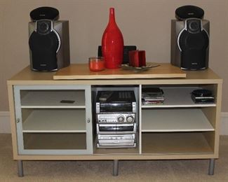 IKEA Tv Stand, Blonde with Brushed Chrome Trim(51”W x 25.5”H x23.5”D). Aiwa Audio Digital System CX-NMA845 3CD Changer AM/FM Digital Audio. Compact Stereo System w/Speakers. Also showing a Fitzgerald & Floyd Flame Red Bottle Vase (15”H)