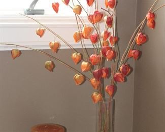 Orange Tone Pillar Candle on Wood Stand and Faux Orange Pod Floral Arrangement in Clear Cylindrical Glass Vase