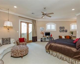 View of Upstairs Bedroom Suite with Kidney Shape Sof, Leopard Print Barrel Chair and Zebra Print Round Ottoman. Queen Bed with Custom Silk Bed Set.