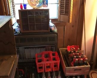 Colored bottles in window,  Pepsi and Coke wooden cases and bottles