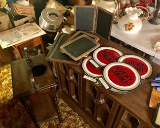 Old chalk boards, Lucky Strike signs all setting on stereo cabinet, smoking stand and more