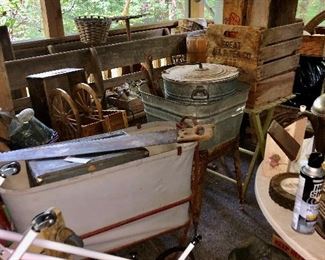 Back porch;  2 nice long wood benches , wooden crates,  galvanized square tub on stand, galvanized tub with lid, baby cradle(white in red frame, lots of hand saws all different sizes.