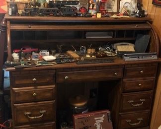 Desk with lots of great small, vintage glasses, knives, cast iron train, Woody on his horse ,"Nothing says lovin" sign